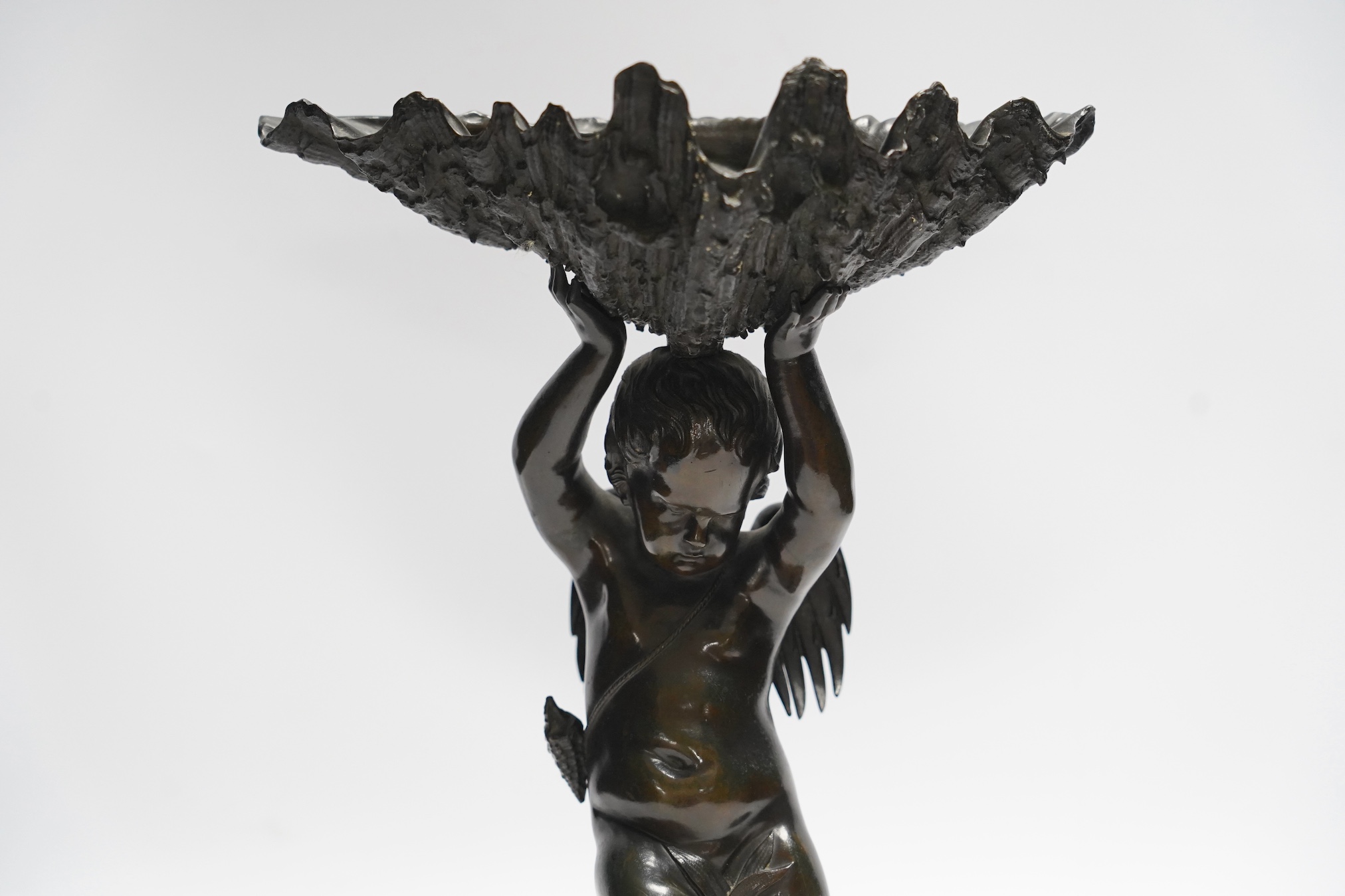 A 19th century bronze figure or centrepiece in the form of putti holding a shell, 34cm